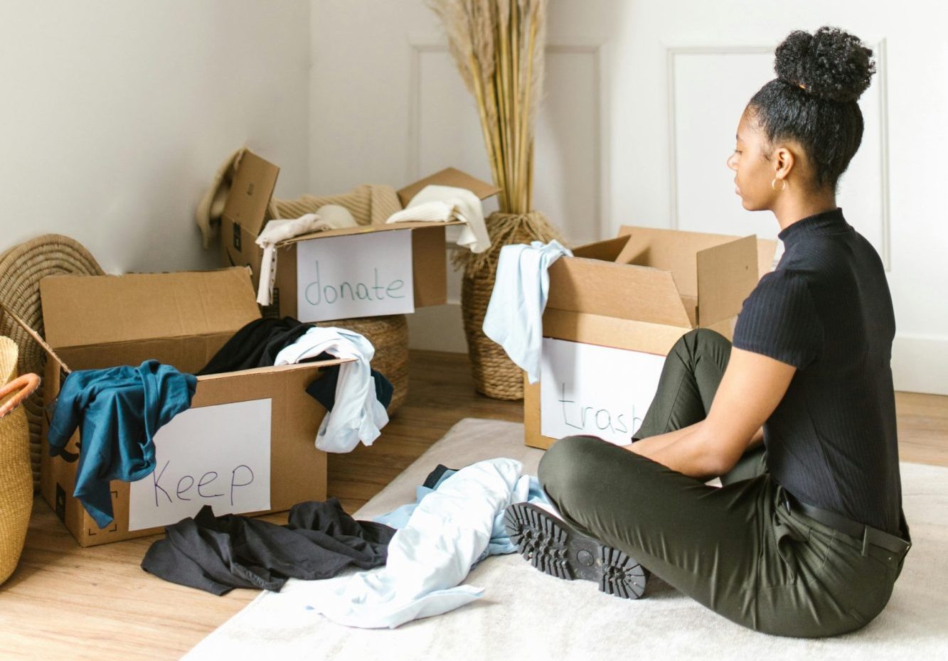 woman sitting on rug organising clothes